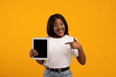 Güzel siyah kadın boş ekran ile dijital tableti işaret ediyor