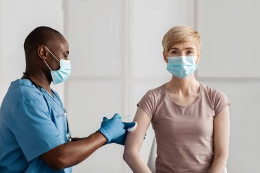 Aşı, aşı, hastalık önleme. Maskeli yetişkin kadın kovid 19 veya grip aşısı olur.