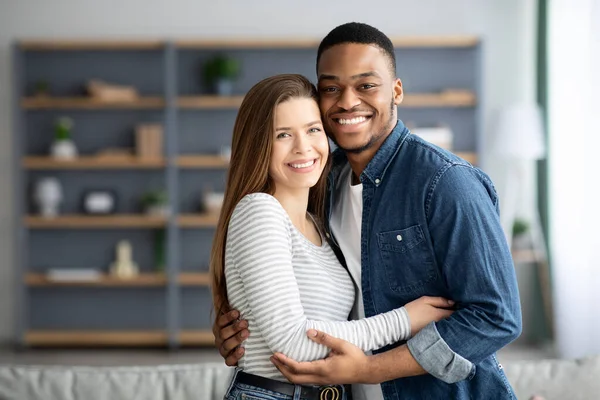 Portrait Of Romantic Interracial Couple Embracing And Smiling At Camera