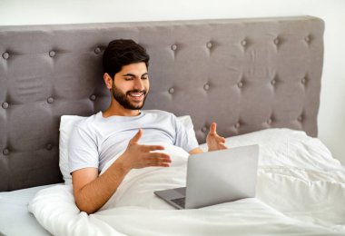 Mutlu Arap adamın dizüstü bilgisayarında görüntülü araması, hafta sonu evde oturup ailesiyle uzaktan konuşması.