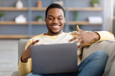 Siyahi adamın görüntülü konuşma yaptığı, dizüstü bilgisayar kullandığı yakın plan.