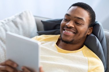 Dijital tablet kullanan gülümseyen siyahi adama yakın çekim