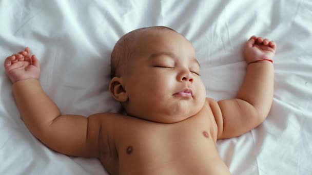 Yeni doğan Afro-Amerikan bebeğinin beyaz yatakta uyuması, sağlıklı uyku konsepti. — Stok video