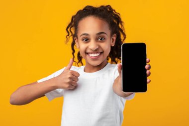 Siyah kız boş akıllı telefon ekranı ve başparmak kaldırıyor