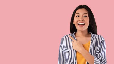 Gülümseyen Asyalı kadın fotokopi alanını işaret ediyor