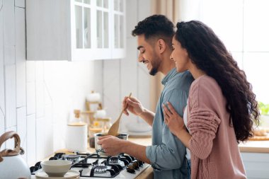 Birlikte Yemek Pişirme Konsepti. Genç Arap eşler mutfakta yemek hazırlıyorlar.