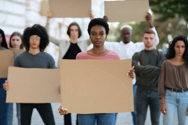 Siyahi kadın sokakta bir grup göstericiyi yönetiyor.