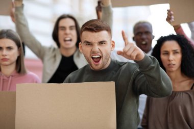 Sokaktan geçen boş tahtaları olan çok ırklı göstericiler