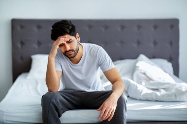 Sabahları kötü bir ruh hali. Depresyondaki Arap adam yatakta oturup sorunları düşünüyor, boşluğu kopyalıyor.