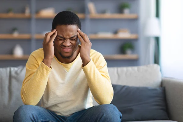 Agacé jeune homme afro-américain ayant mal à la tête — Photo