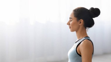 Yoga yapan kadının evde meditasyon yapmasına yakın çekim.