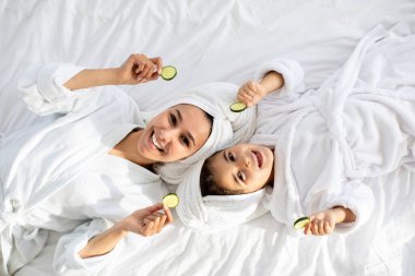 Anne ve kızının yatakta yatışının en üst görüntüsü.