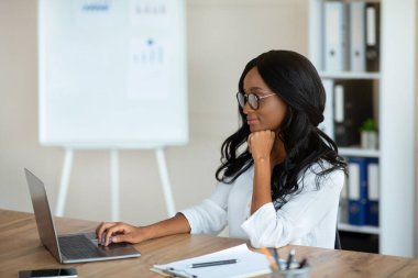 Bilgisayarlı iş kadını. Ofisinde iş yazışmalarıyla çalışıyor.