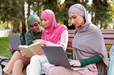 Bilgisayarları kullanarak ve dışarıda kitap okuyarak öğrenen üç İslami Kadın