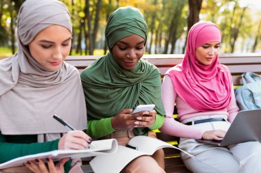 Modern Müslüman Bayan Öğrenciler, dışarıda bilgisayar ve telefon kullanmayı öğreniyor.