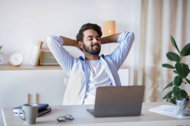 Başarılı çalışma günü. Yakışıklı Arap İş Adamı Ofiste Arkaya Yaslanıyor