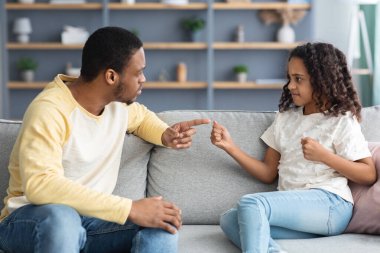 Ciddi bir siyah baba öfkeli kızını azarlıyor.