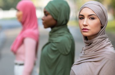 Dışarıya poz veren üç farklı Müslüman kadının Yan-Görünüm Grubu Portresi