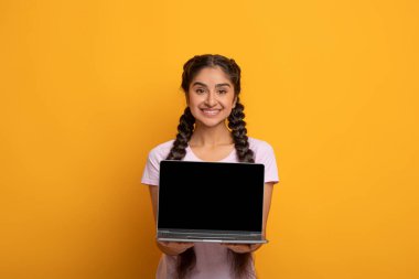 Gülen Hintli kadın boş laptop ekranı gösteriyor