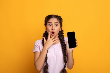 Şaşırmış Hintli kadın boş akıllı telefon ekranı gösteriyor