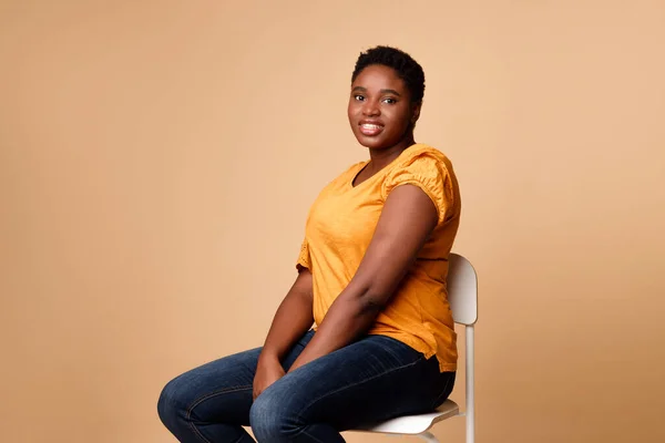 Black Woman Waiting For Covid-19 Vaccination Sitting Over Beige Background