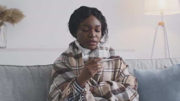 Zieke Afro-Amerikaanse vrouw die de temperatuur thuis meet, koorts ziet en wanhoop voelt, slow motion — Stockvideo