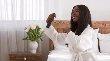 Afrikalı Kadın Saç Fırçalayan Saç spreyi Salonda Oturuyor