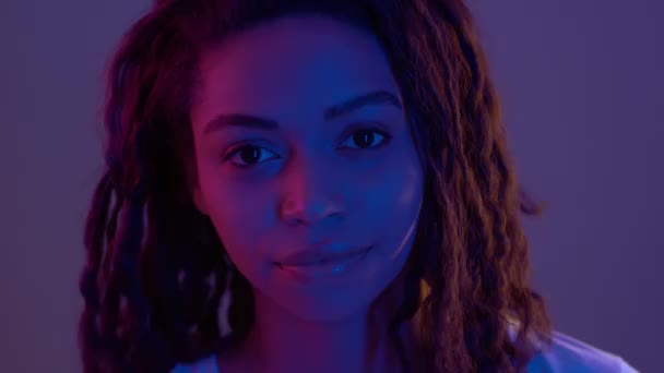 Használd az eszed. Stúdió portré fiatal afro-amerikai nő mutatva a fejét neon fények — Stock videók