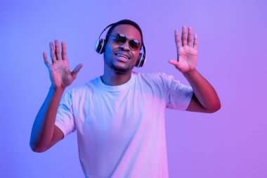 Ritmi hisset. Kablosuz kulaklıklı siyah adam müzik dinliyor ve dans ediyor.