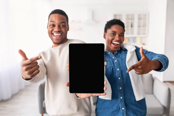Black couple showing blank empty tablet screen for mock up