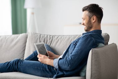 Gülümseyen sakallı adam boş ekranlı dijital tablet kullanıyor