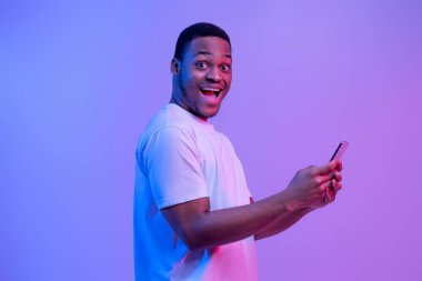 Mobil Teklif. Heyecanlı Afrikalı Amerikalının Portresi Akıllı Telefonu Tutuyor, Neon Light