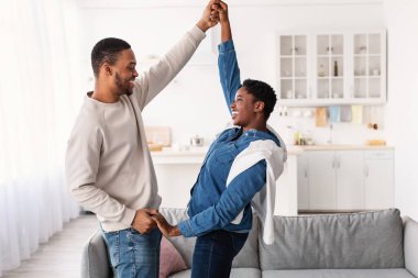 Evde dans eden neşeli siyah çiftin portresi.