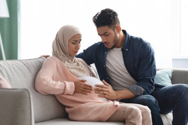 Acılı Bebek Hareketleri. Hamile Müslüman Kadın Evde Abdominal Aci cekiyor