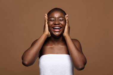 Gençleştirme kavramı. Güzel siyah kadın yanaklarına dokunuyor.