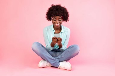 Neşeli Siyah Kadın Akıllı Telefon Mesajı Kullanıyor Pembe Arkaplanda Oturuyor