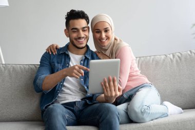 Orta Doğulu erkek ve kadın dijital tablet ekranına bakıyor