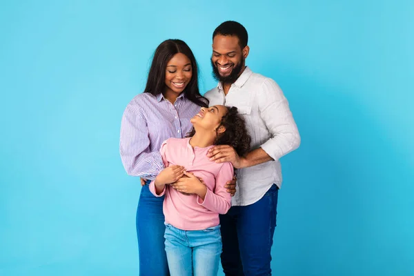 Hombre afroamericano abrazando a su esposa e hija sonriente — Foto de Stock