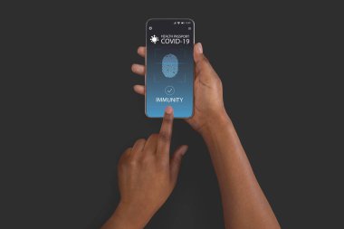 Siyah kadın dijital bağışıklık sistemine sahip akıllı telefon kullanıyor. Covid-19 için pasaport.