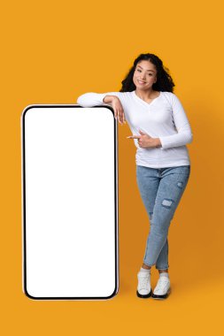 Gülümseyen Afrikalı Amerikalı Kadın Büyük Akıllı Telefona Beyaz Ekran ile yaslanıyor, Mockup