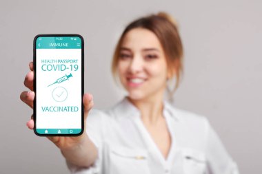 covid-19 için immün dijital pasaportlu akıllı telefon gösteren bir kadın