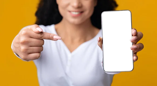 Tanımlanamayan, gülümseyen siyah kadın Beyaz Ekran ile Akıllı Telefon 'u işaret ediyor — Stok fotoğraf
