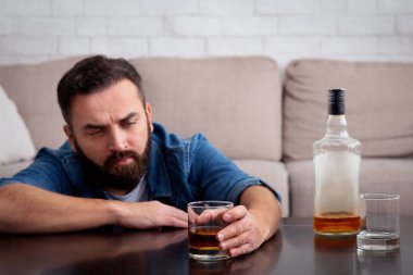 Üzgün, depresif, bağımlı, alkolik, alkol bağımlısı.