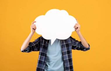 Tanımlanamayan genç adam, turuncu arka planda boş konuşma baloncuğu tutuyor, tasarım için model.