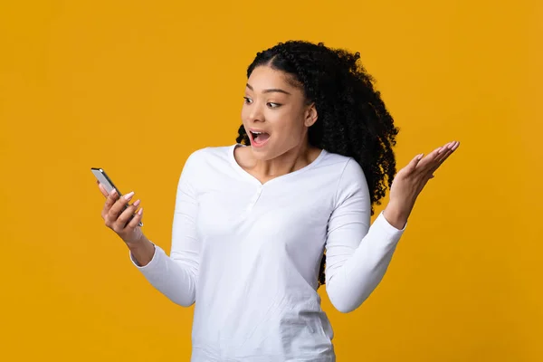 Mobilní nabídka. Překvapená černošky žena při pohledu na obrazovce Smartphone, křičí s vzrušením — Stock fotografie