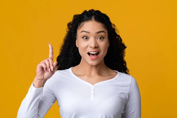 Spännande ung afrikansk dam höja fingret upp, har en idé — Stockfoto