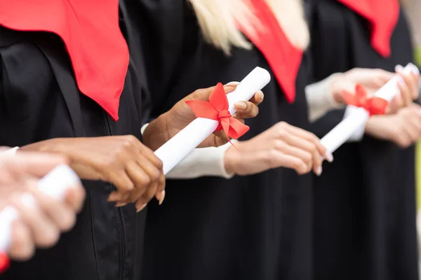Oigenkännlig multiracial grupp av akademiker som innehar diplom — Stockfoto