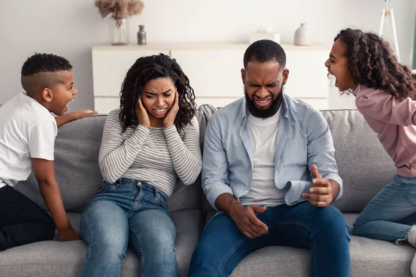 Angry black children fighting over their shocked parents — Stock Photo, Image