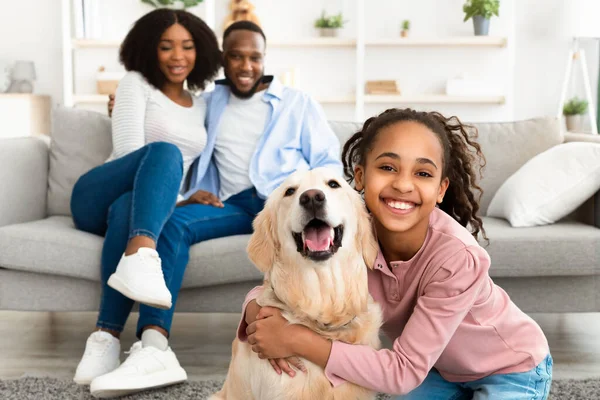Jong zwart meisje knuffelen met hond poseren thuis — Stockfoto