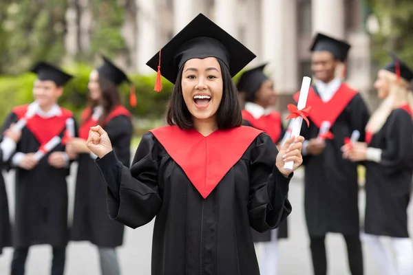 Encantado asiático jovem senhora estudante na graduação traje — Fotografia de Stock